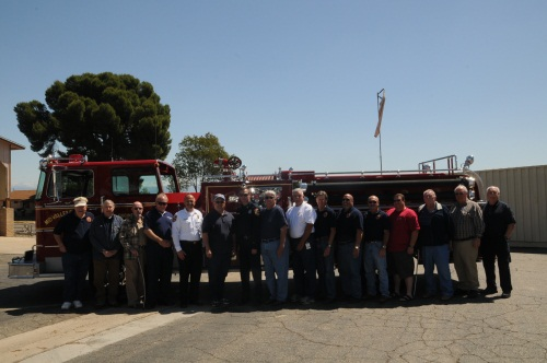 Board of Directors and staff standing in front of engine