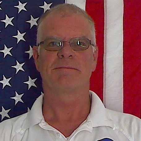 May contain: american flag, flag, face, head, person, photography, portrait, adult, male, man, accessories, and glasses