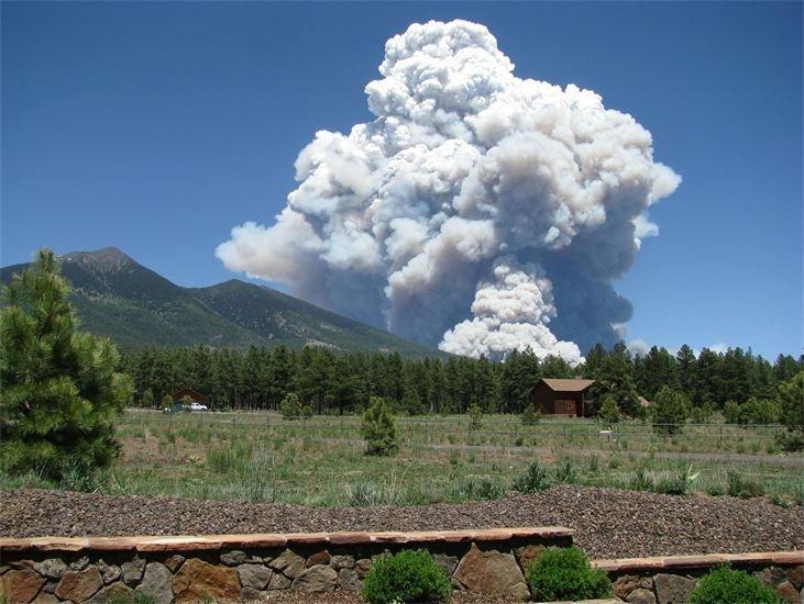 Photograph of smoke rising over a mountain