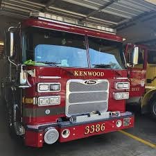 The image features a red fire truck parked inside a garage, labeled "KENWOOD" with the number "3386."