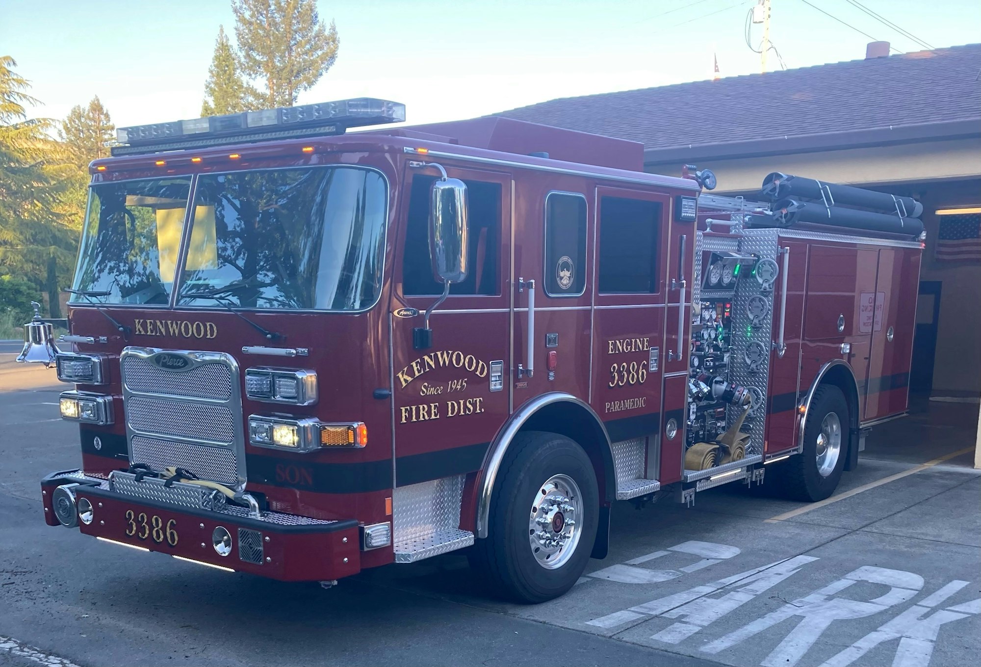 Red Kenwood fire truck parked outside a fire station.