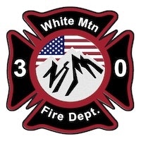 A fire department emblem with mountains, an American flag, and the text "White Mtn Fire Dept. 3 0."