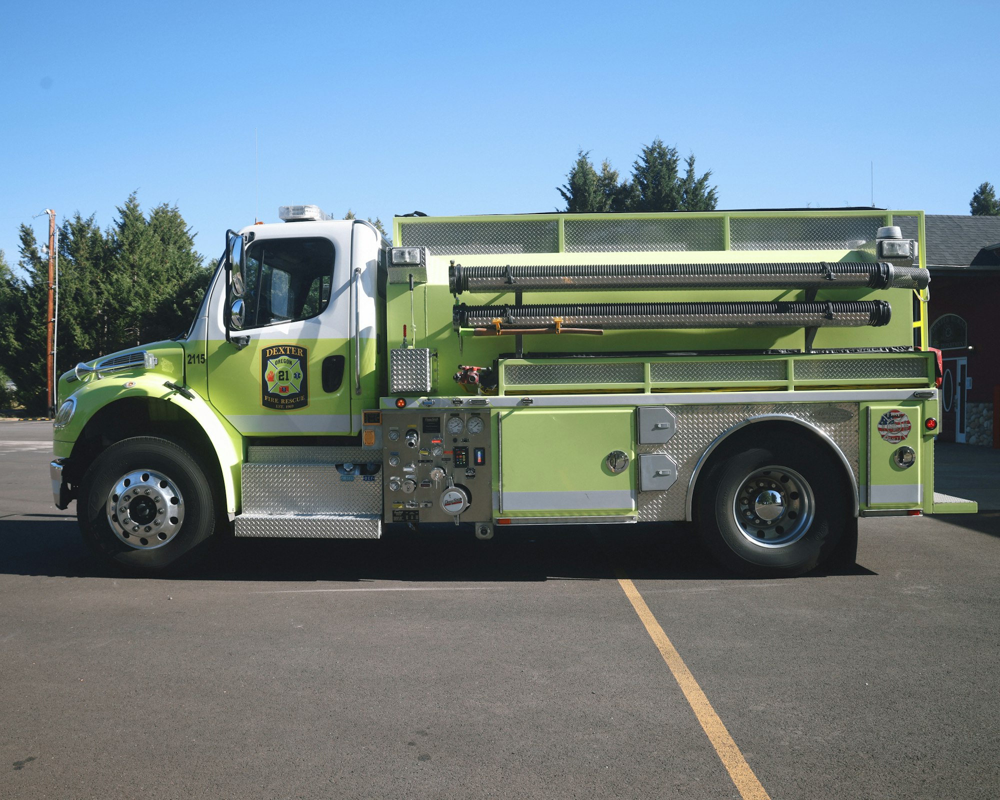 A lime-green fire truck parked outdoors on a sunny day.