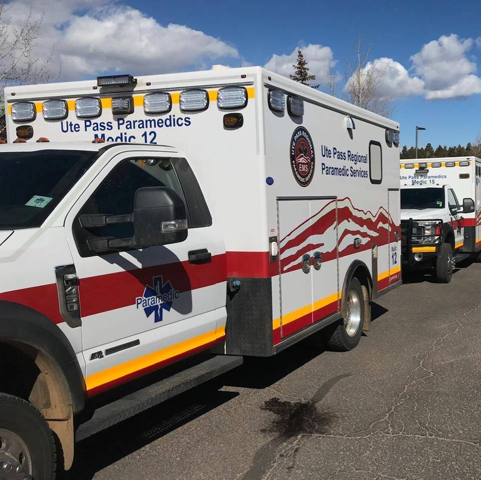 The image shows a line of Ute Pass Paramedics emergency vehicles, marked with red and white colors.
