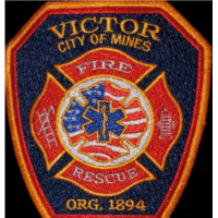 The image features a badge for the Victor City of Mines Fire Rescue, established in 1894, with symbols representing fire and emergency services.