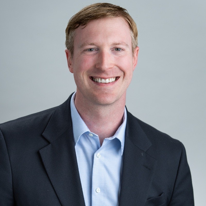 A person in a suit smiling at the camera.