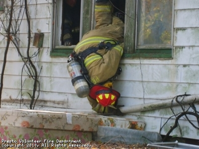 Photo of firefighter climbing out of window