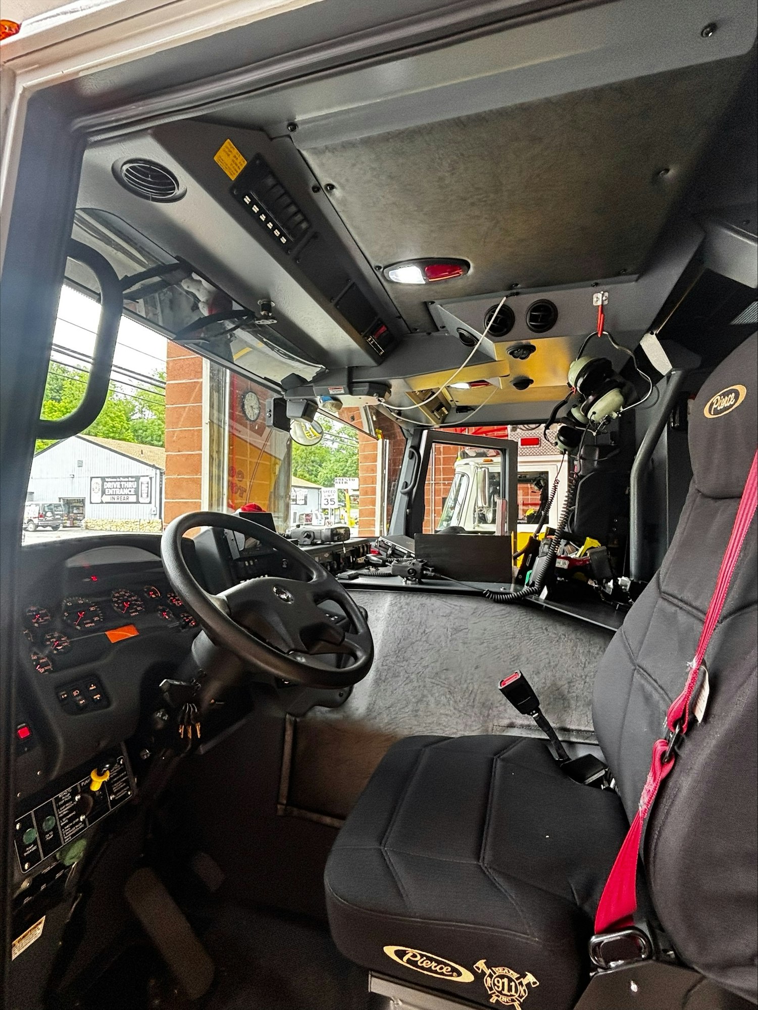 The image shows the interior of a fire truck, featuring the driver's seat, dashboard, and various controls.
