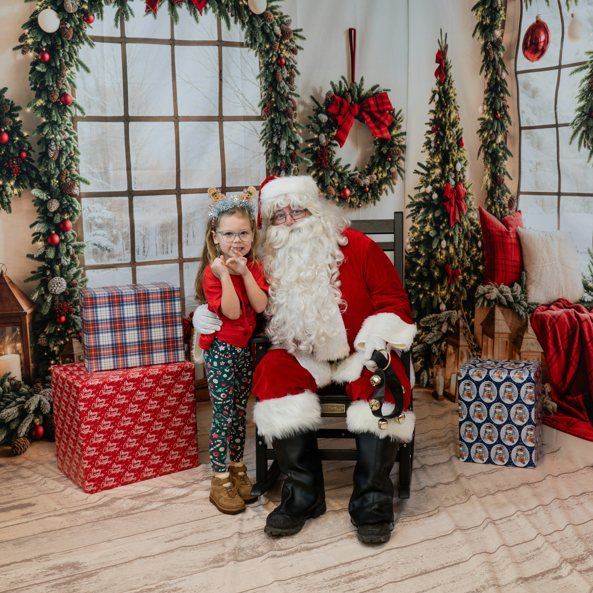 A child with Santa Claus in a festive setting with Christmas decorations and gifts.
