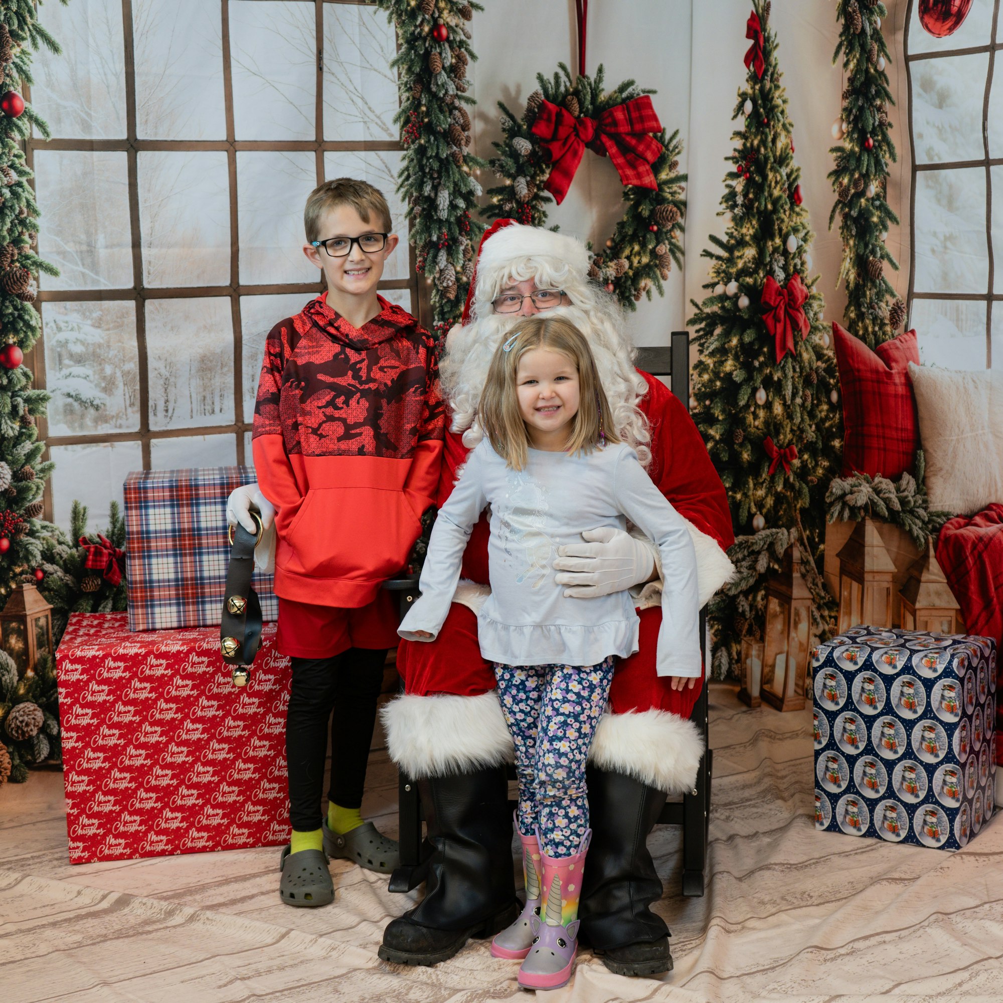 Kids with Santa Claus in a festive setting, surrounded by Christmas decorations and presents.
