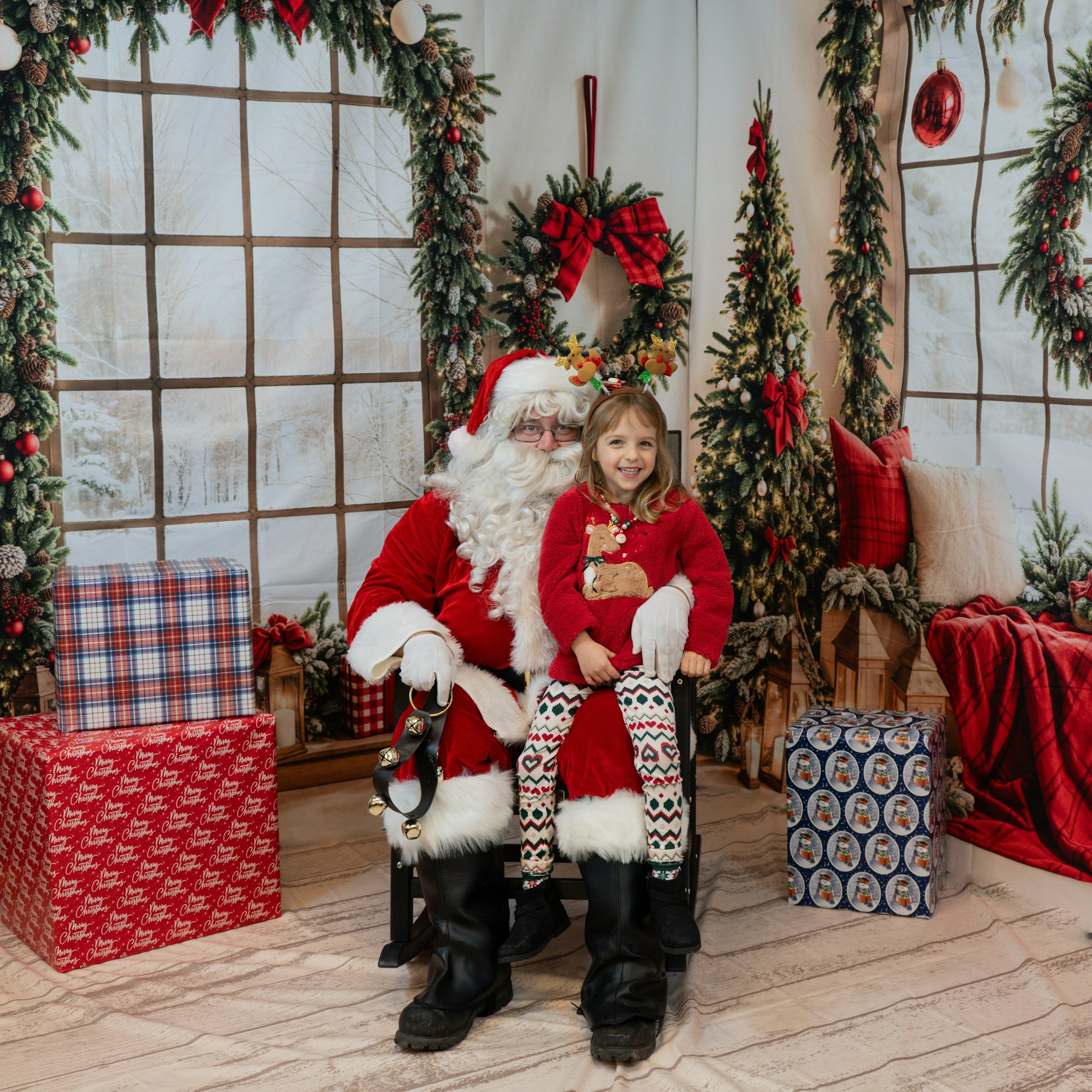 Santa and a child in a festive setting with Christmas decorations and gifts.