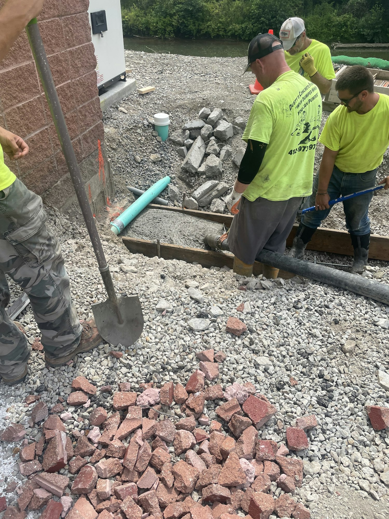Construction workers with tools working among broken bricks and gravel.