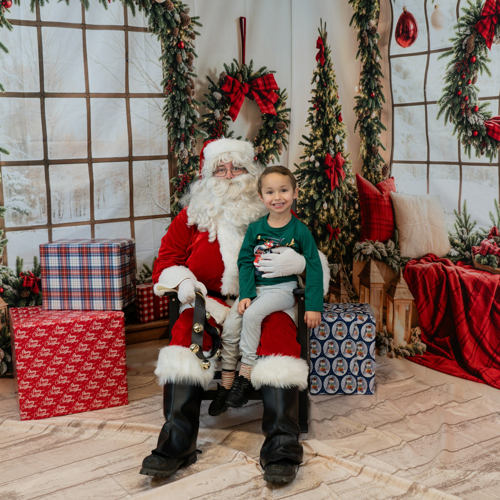 A child sits on Santa's lap amid Christmas decorations and wrapped gifts.