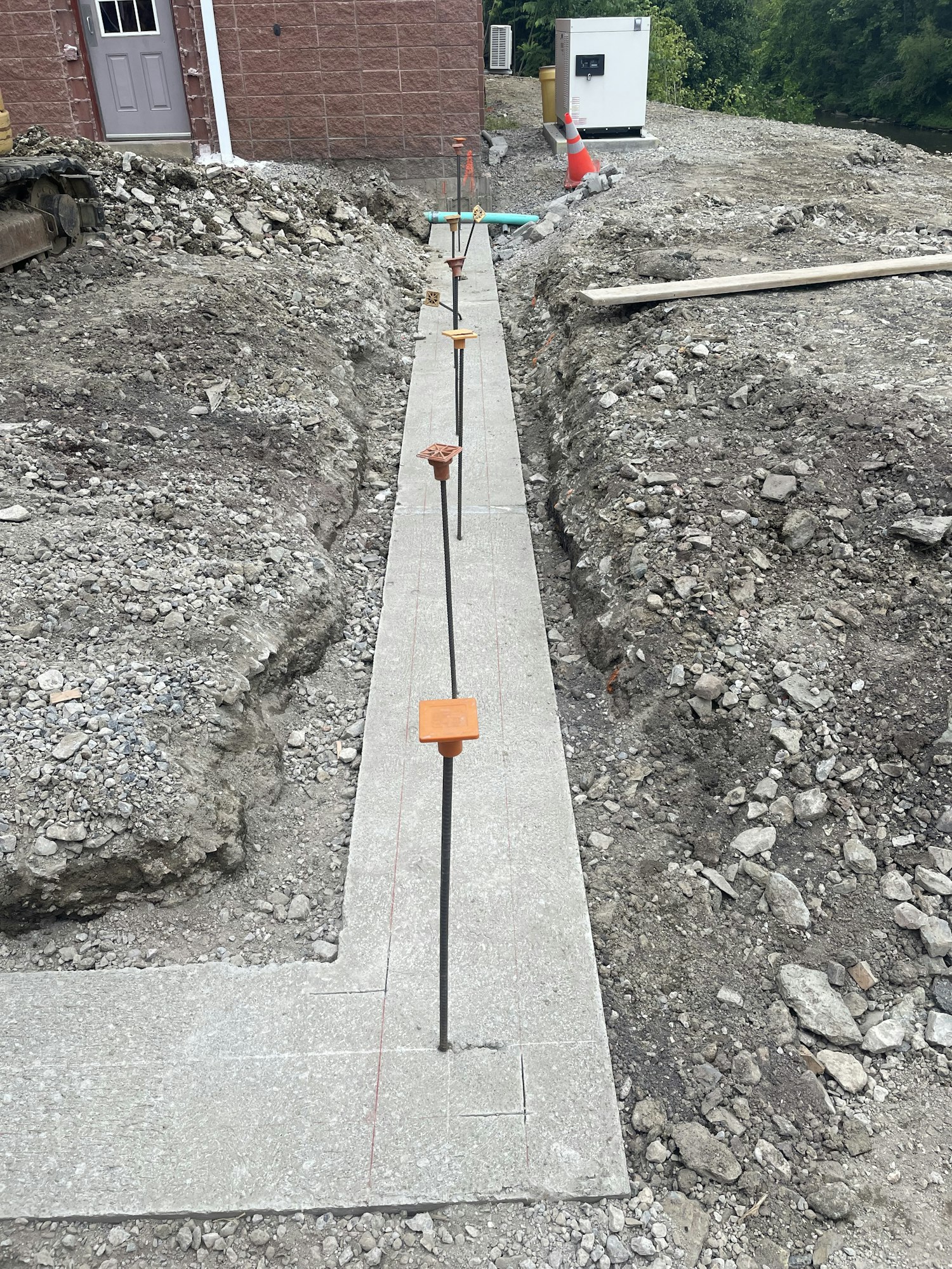 A pathway under construction with paving stones, surrounded by gravel and construction materials. Image is rotated 90 degrees.