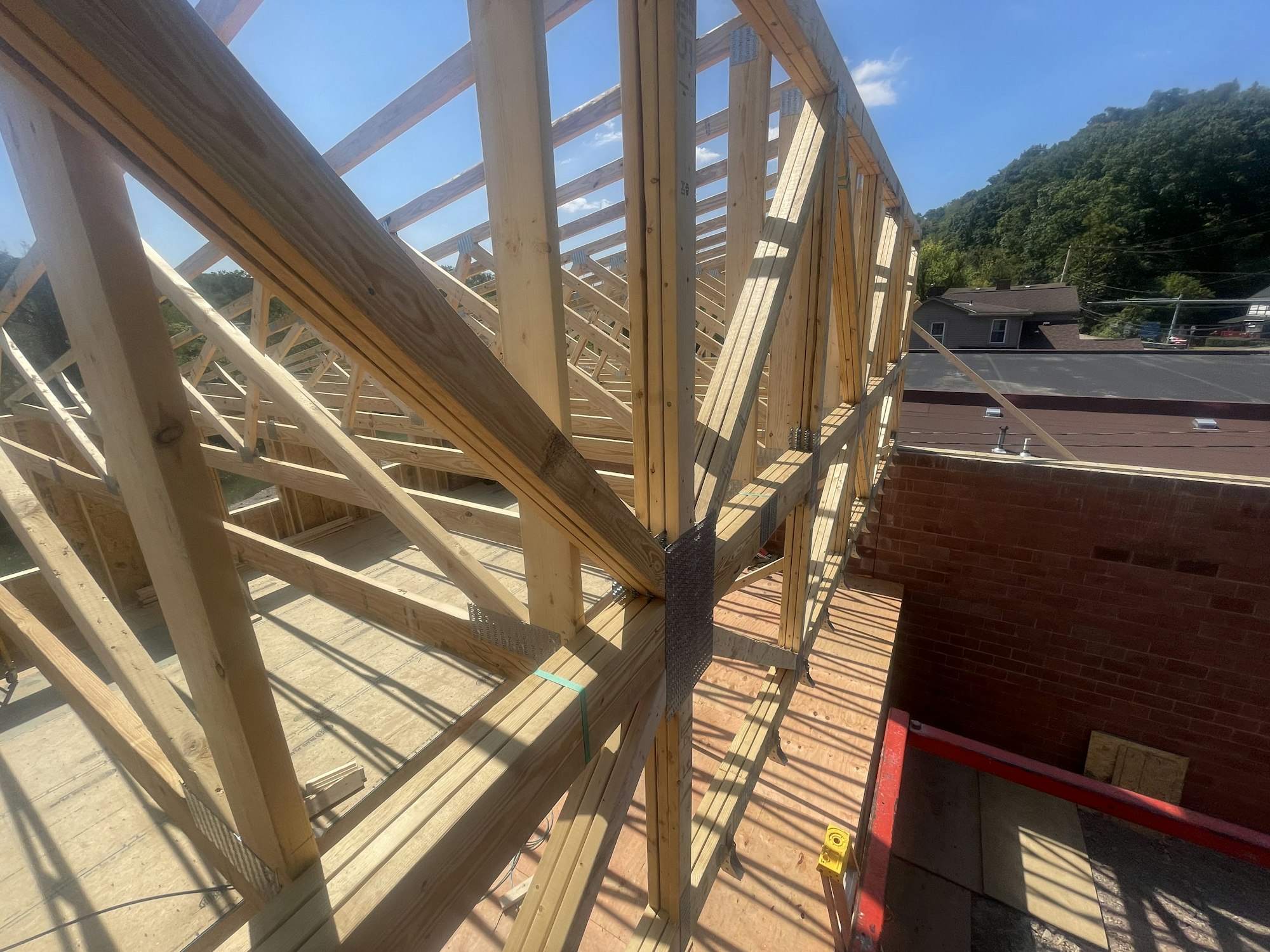 Wooden house frame under construction with clear skies.