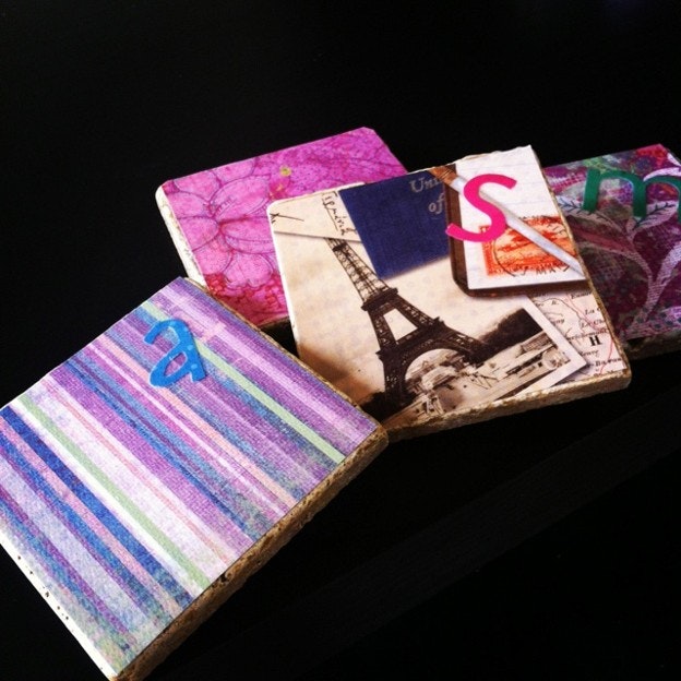 The image shows colorful coasters with patterned designs and letters on them, including an Eiffel Tower graphic.