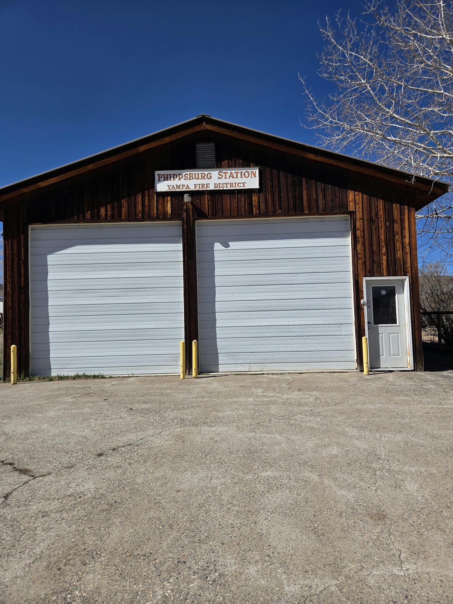 An entrance to a building marked "Pumpsburg Station, Fire District," featuring two large garage doors and a door on the side.