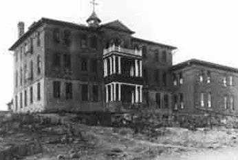 Old, dilapidated building with boarded windows and a damaged facade.