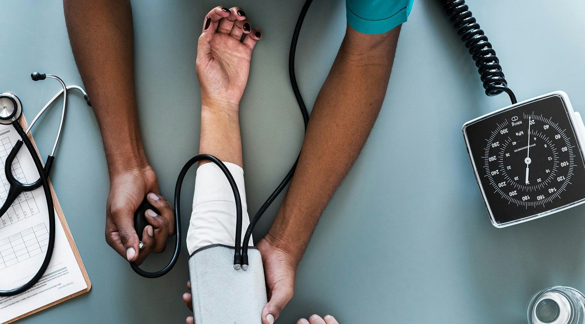 A patient's arm getting a blood pressure check by a healthcare professional.