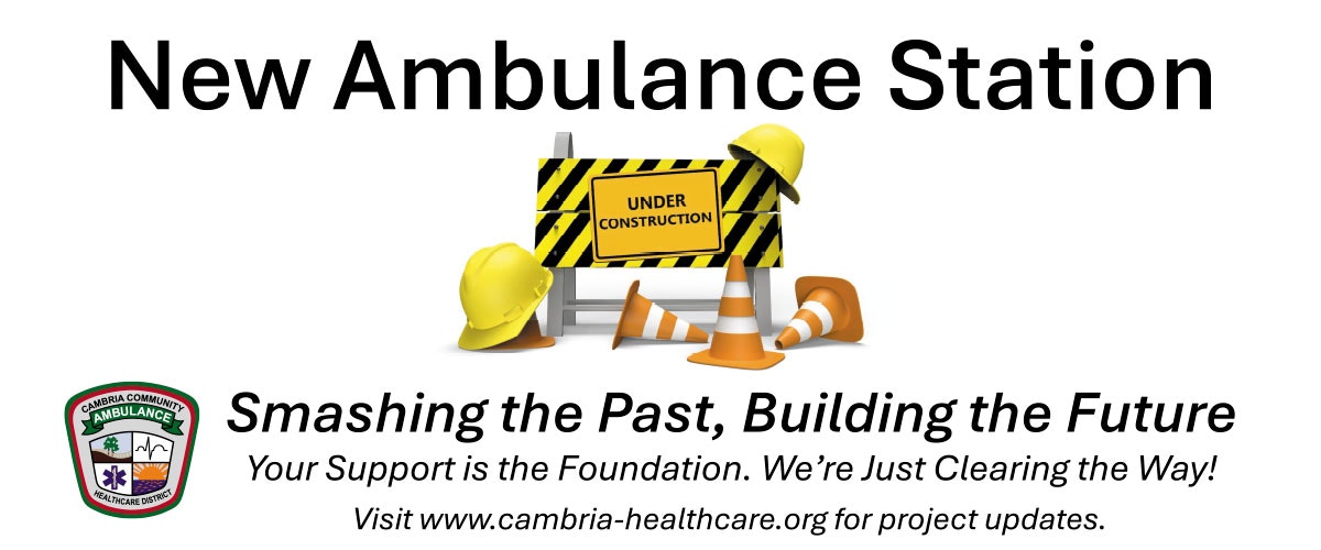New ambulance station under construction announcement with safety equipment and a website link for updates.