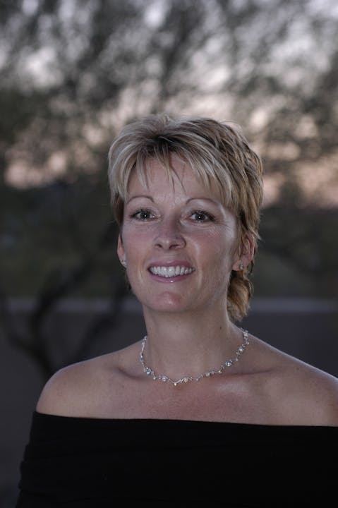 May contain: clothing, dress, evening dress, formal wear, person, face, happy, head, smile, photography, portrait, accessories, jewelry, necklace, body part, and neck