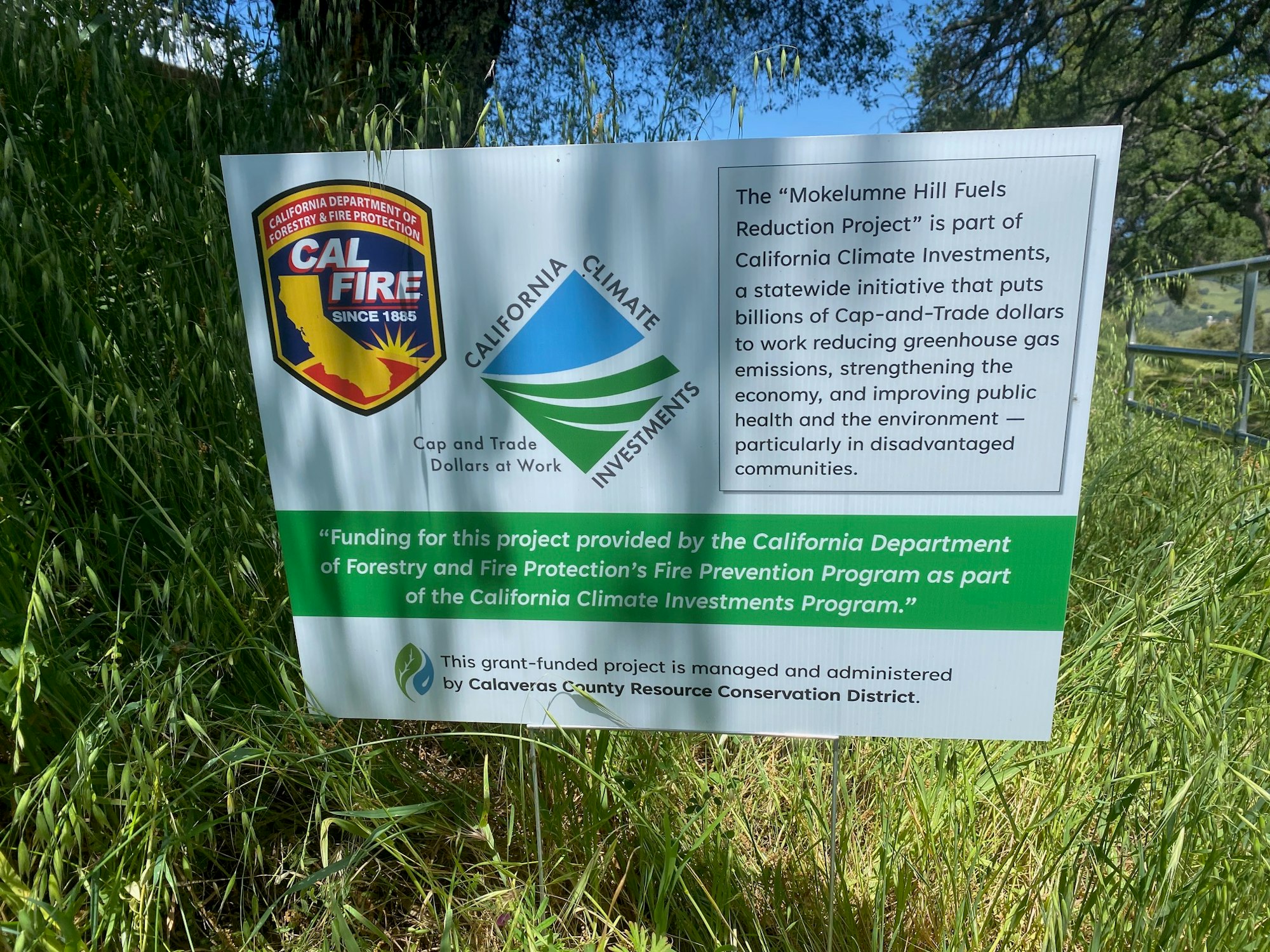 A sign about the Mokelumne Hill Fuels Reduction Project funded by California Climate Investments and Cal Fire, aimed at reducing greenhouse gas emissions.