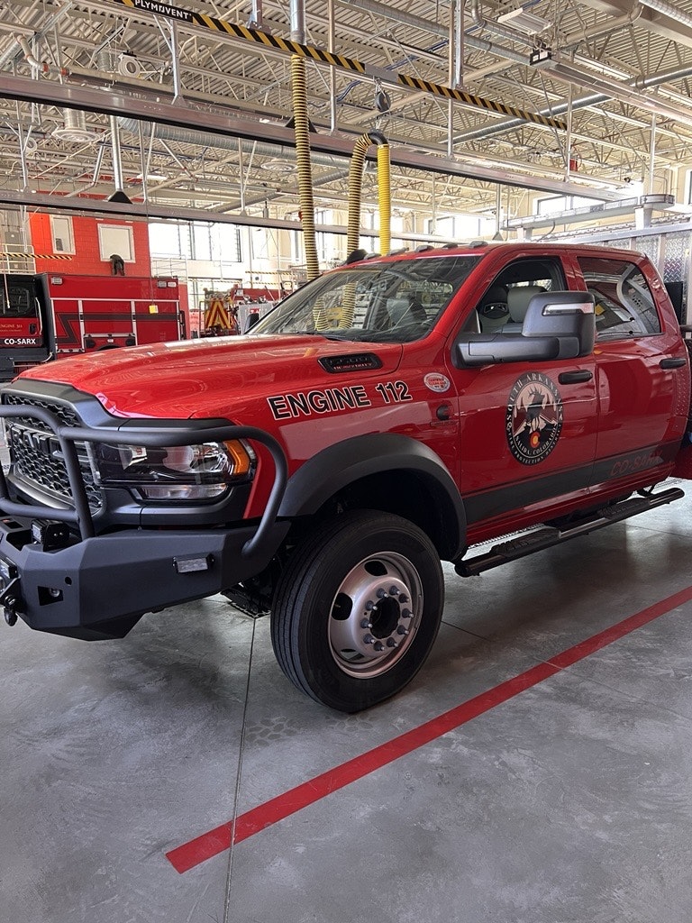 A red fire department truck labeled "ENGINE 112" inside a fire station.