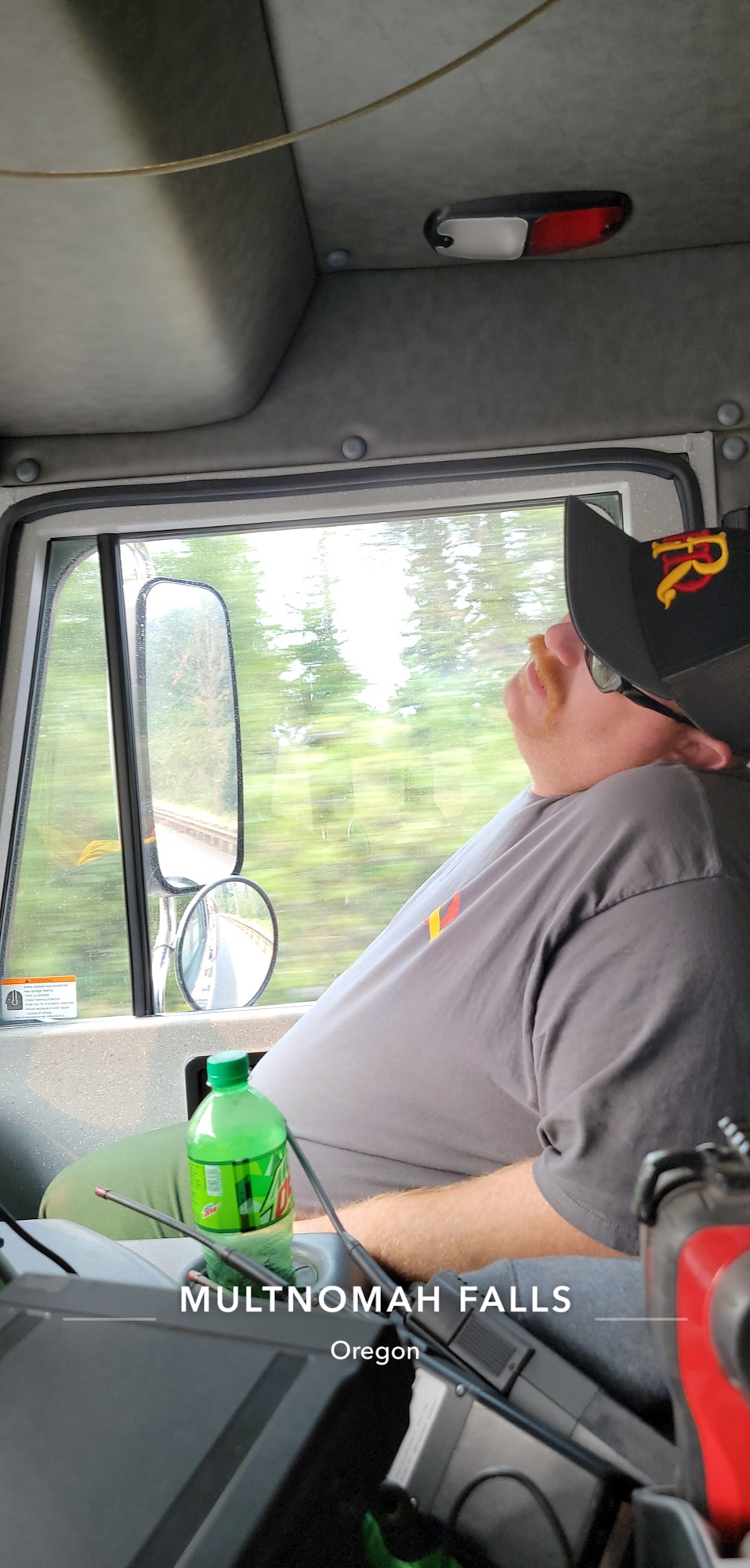 May contain: baseball cap, cap, clothing, hat, cushion, home decor, photography, adult, male, man, person, face, head, portrait, car, transportation, vehicle, and windshield