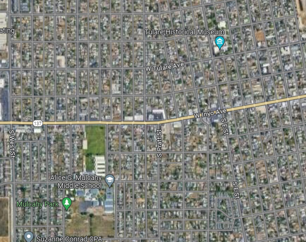 Aerial view of a grid-patterned residential area with streets, a school, park, and historical museum marked.