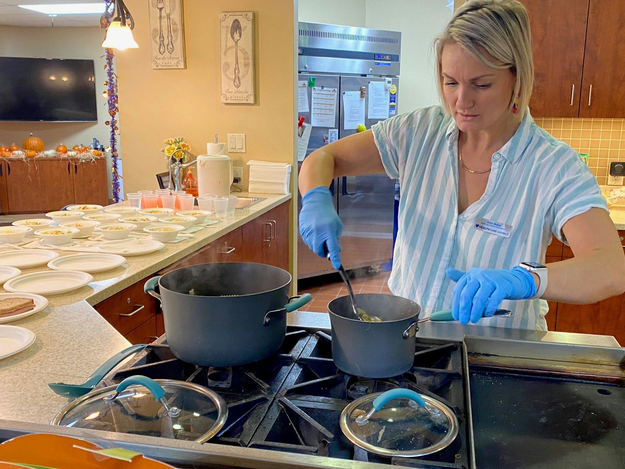 A person is cooking in a kitchen with multiple plates prepared on a counter.