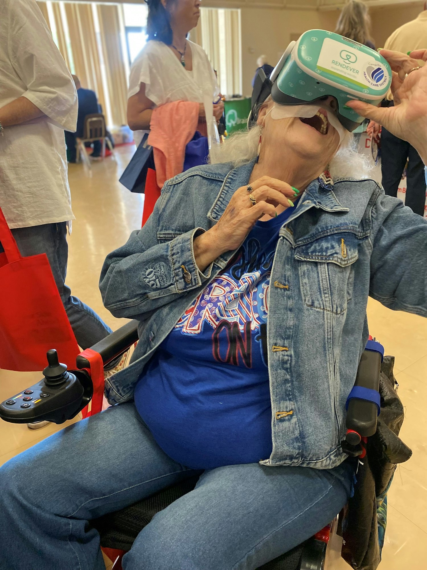 Elderly woman in a wheelchair experiencing virtual reality.