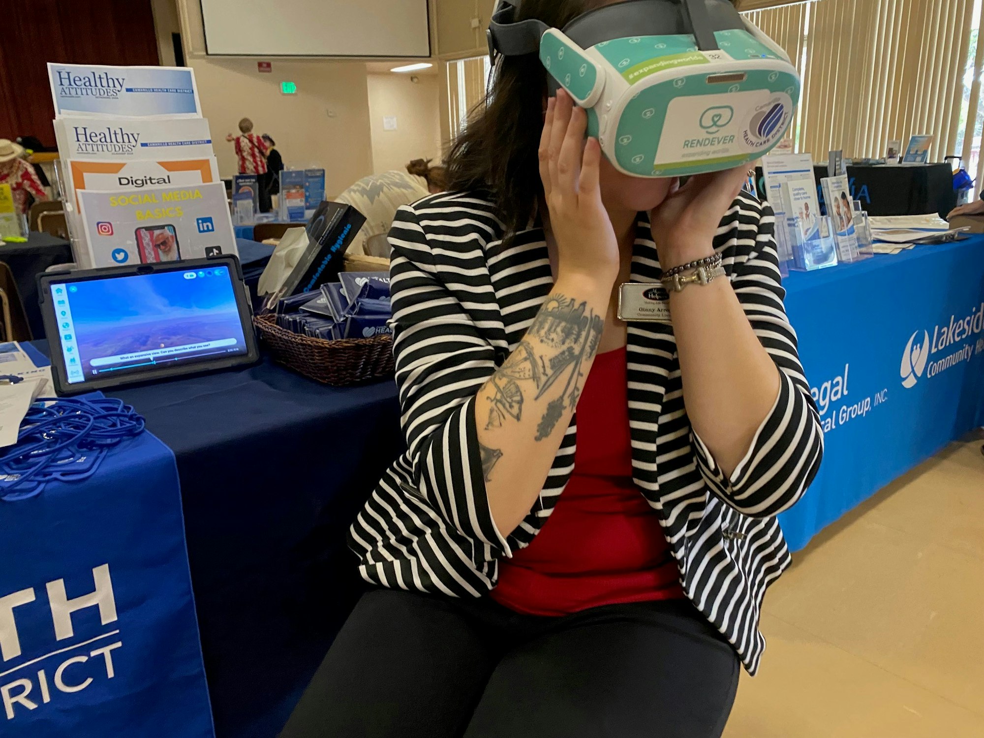 Person using VR headset at a booth with health-related information.