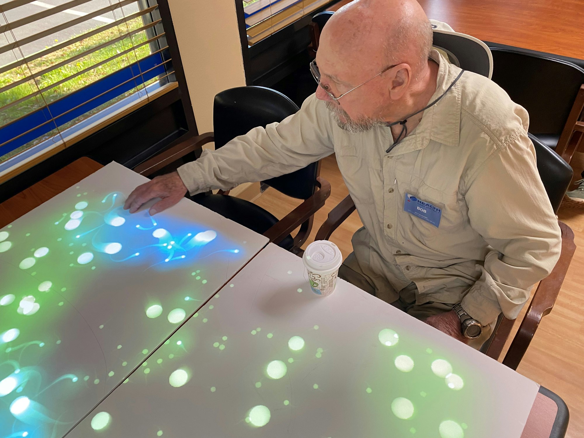 A person interacting with a light-up touch-sensitive table.