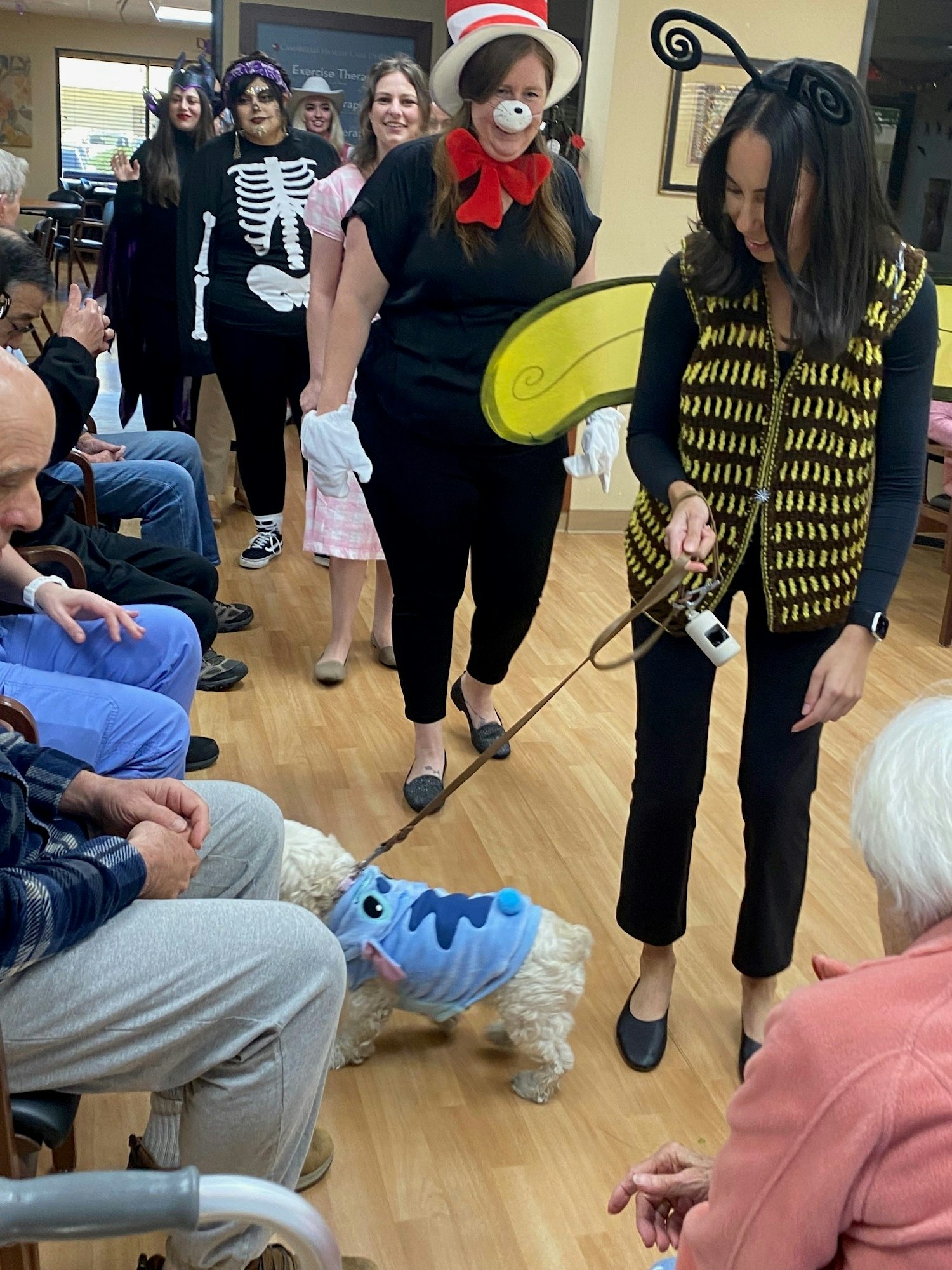 A group of people and a dog in costumes, likely celebrating an event or participating in a themed party.