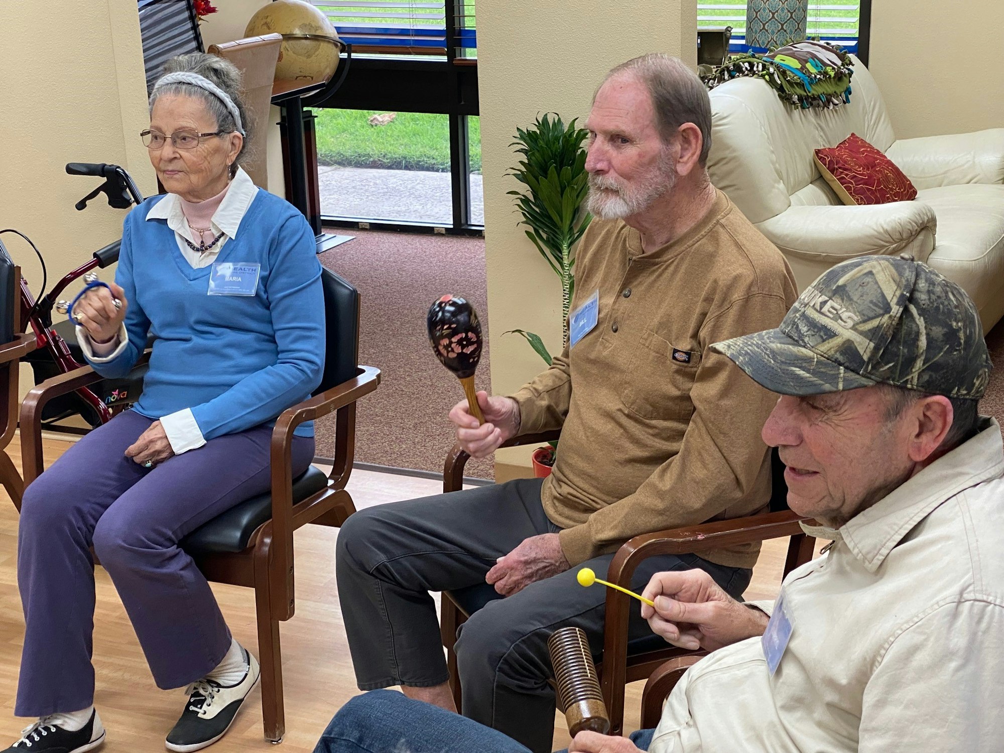 Three people sitting and playing musical instruments.