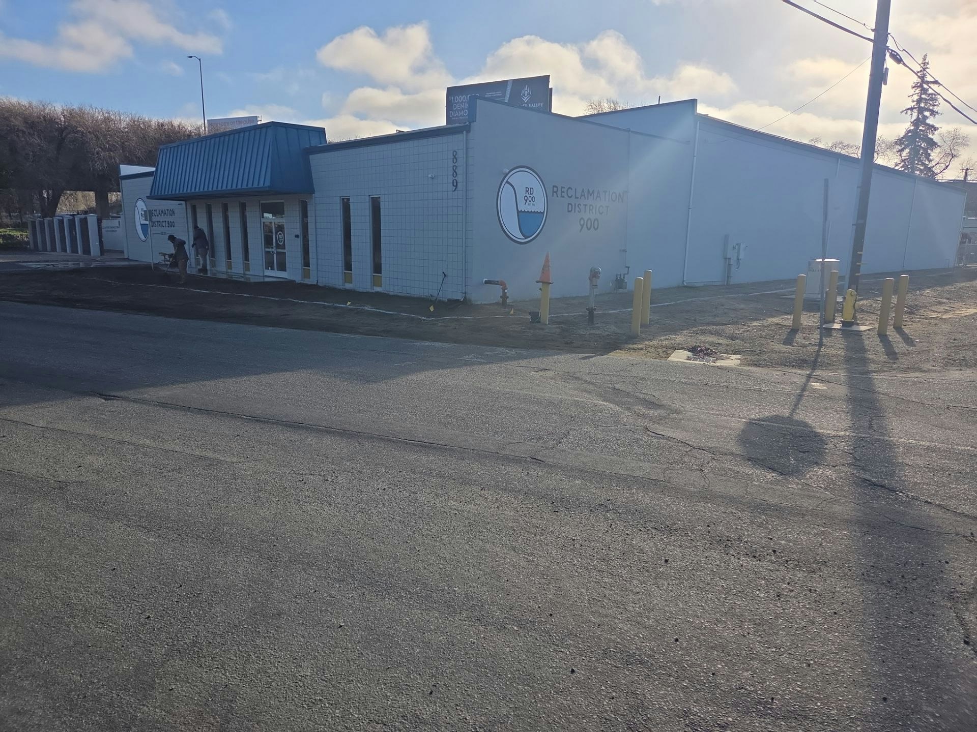 The image shows a building with a blue roof and the words "Reclamation District 900." There are roadworks and utility features nearby.