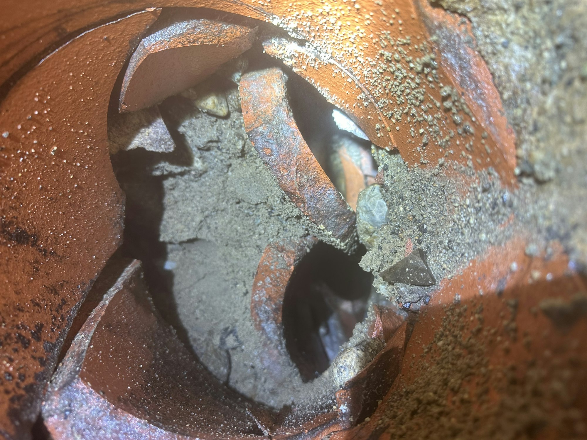 A broken terracotta pot with soil, illustrating texture and fragmentation.