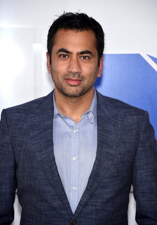 A man in a blue suit and shirt posing for a photo.