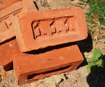 Stack of red bricks with embossed "TEST" on top brick.