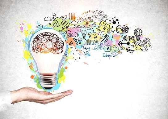 A hand holding a lightbulb with a brain graphic and colorful creative doodles flowing out, representing ideas and creativity.