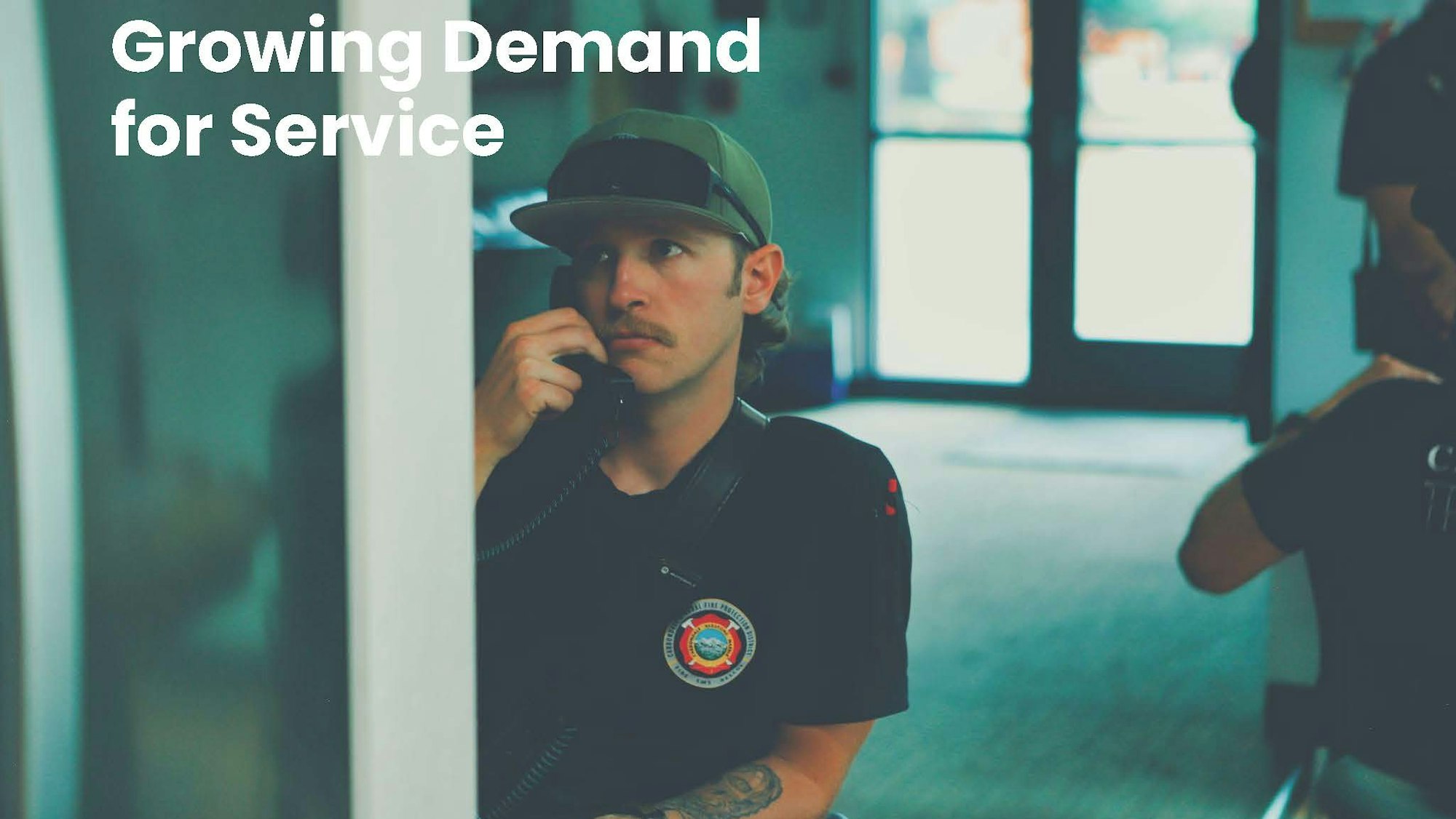A man in a cap with a mustache holds a phone. Text reads "Growing Demand for Service."