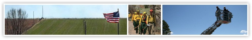 A flag, firefighters, and a person on a lift.