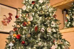 A decorated Christmas tree with ornaments and lights, indoors.