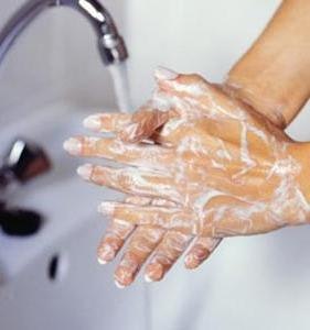 A person washing hands with soap under running water.