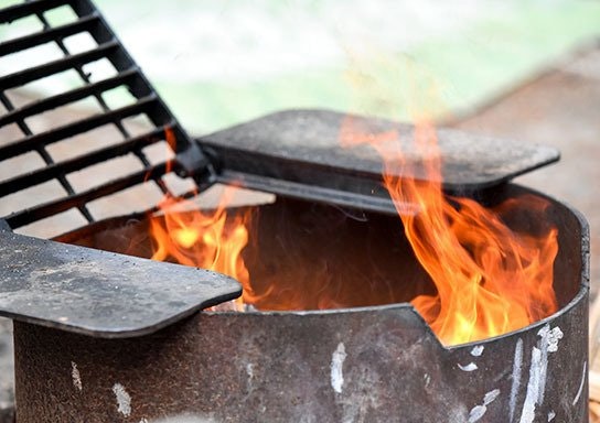 A lit barbecue grill with visible flames.