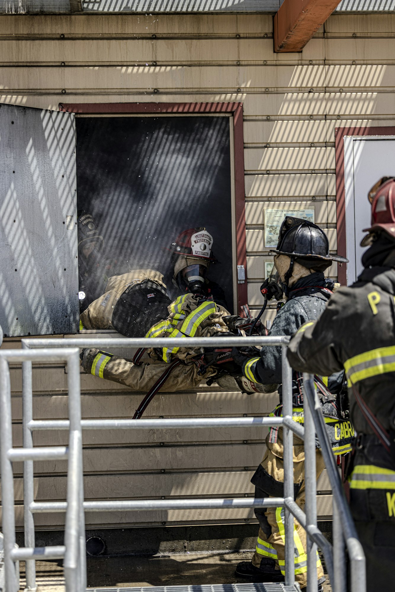 Firefighters are actively rescuing someone from a smoke-filled room, showcasing quick action and teamwork.