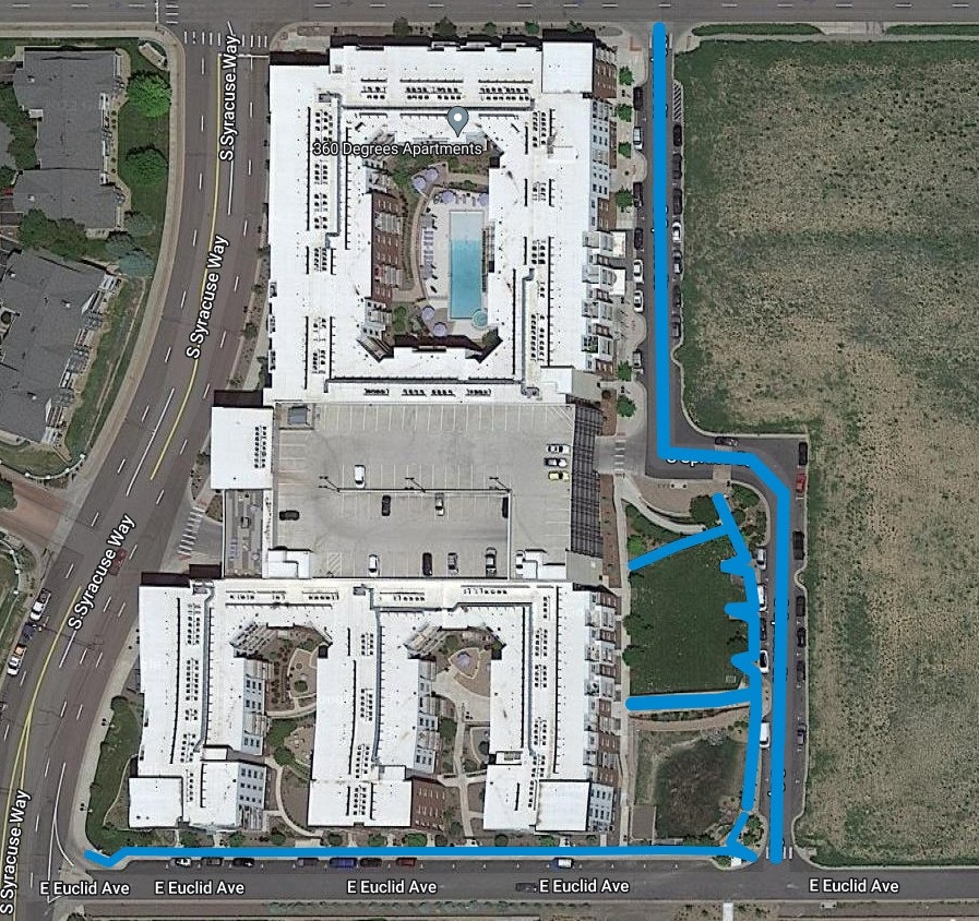 Aerial view of an apartment complex with a pool, roads, and annotations possibly indicating water flow paths.