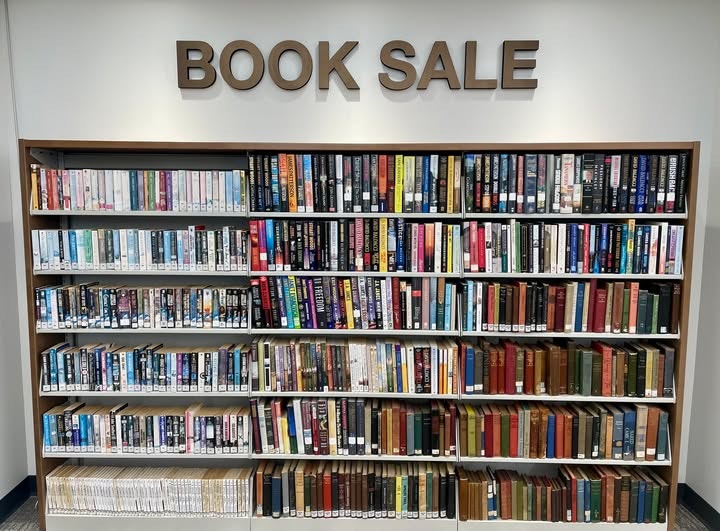 Books arranged on shelves under a "BOOK SALE" sign.