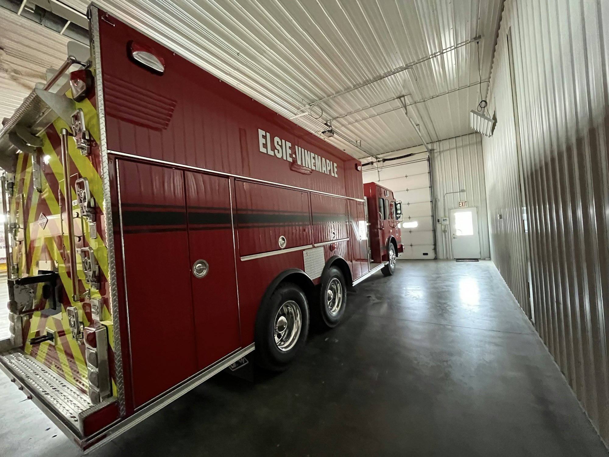 Red firetruck parked inside a station bay with "ELSIE-UNADILLA" text on the side.