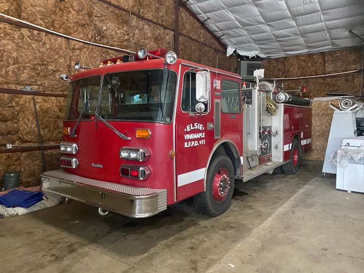 A red fire truck parked inside a garage.